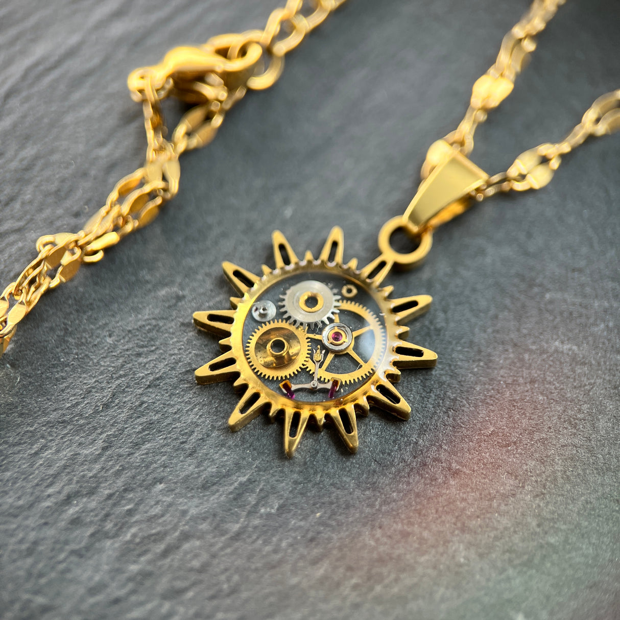 WatchThis „Sol“ handgemachte Halskette – Sonnenförmiger Anhänger aus alten Uhren, 18k vergoldet oder Silber mit Edelstahl. Kettenlänge 44 cm, Anhängergröße 2 cm. Dreizack Wien.