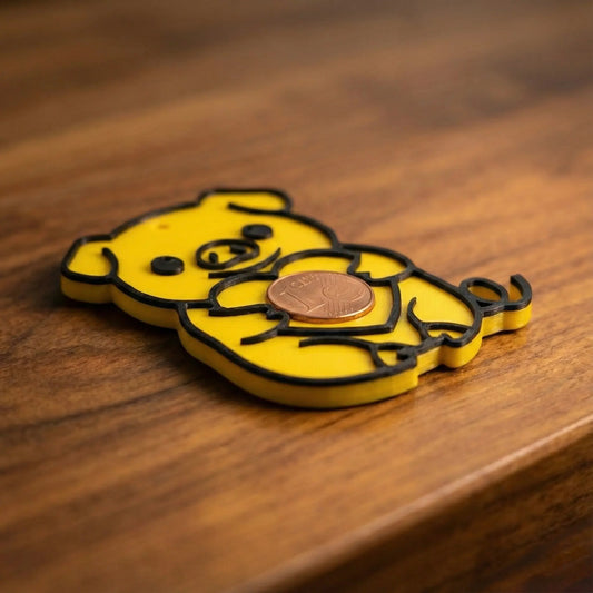 Ein glänzendes, gold-schwarzes 3D-Druck Schweinchen als Glücksbringer, das eine 1-Cent-Münze hält.