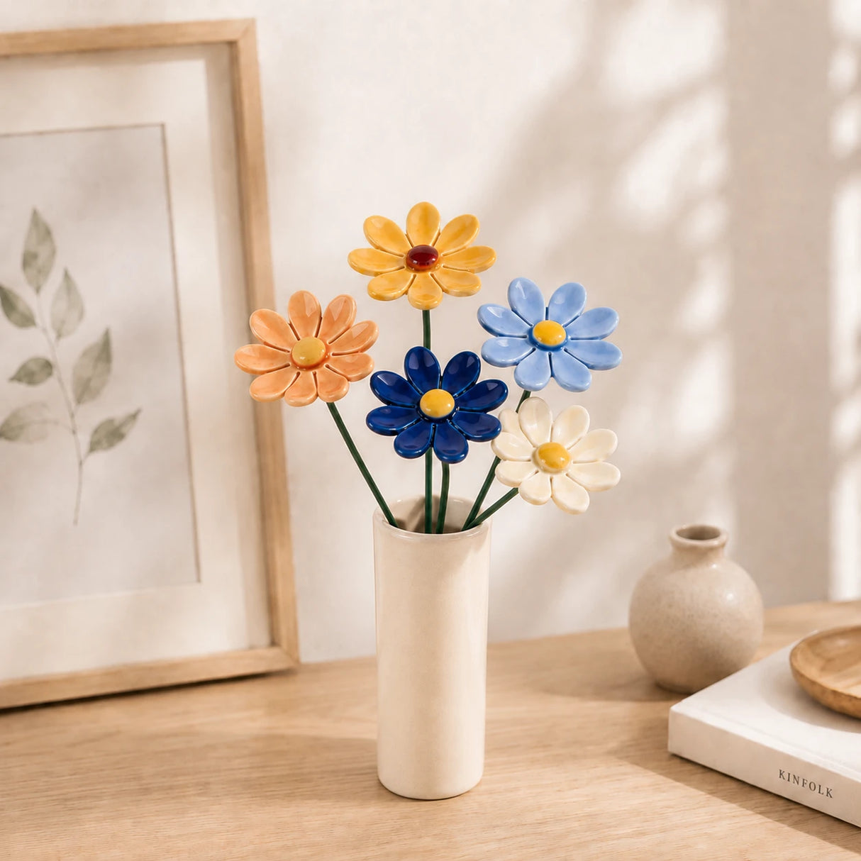 Handgemachte Keramikblumen in Gänseblümchen-Form in einer Vase ausgestellt.