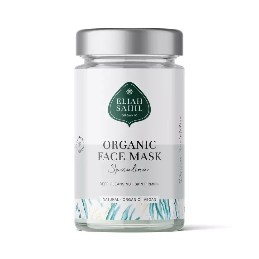 Nahaufnahme einer Bio Gesichtsmaske Spirulina in einer minimalistischen Glasverpackung, daneben eine angerührte grüne Paste. — 100g