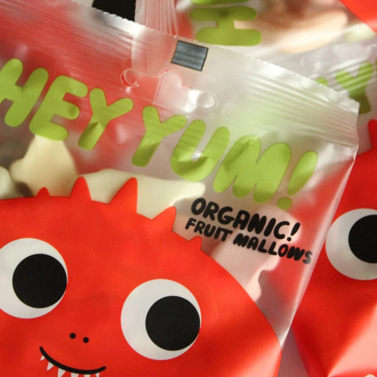 HEY YUM! Bio-Fruchtjoghurt-Gummibärchen in verschiedenen bunten Dinosaurierformen in einer geöffneten Packung.