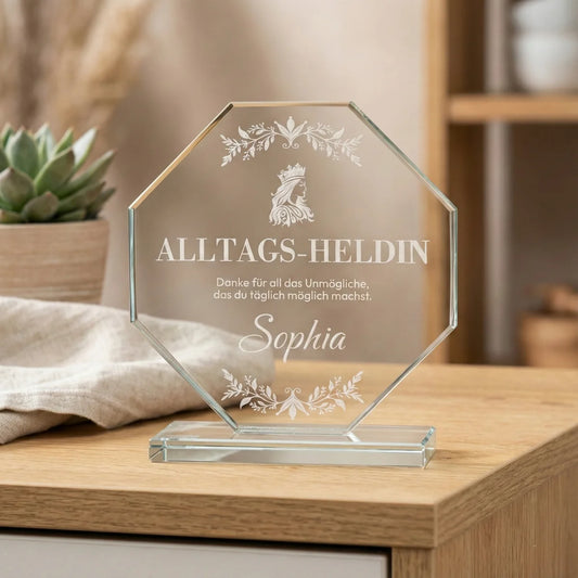 Ein achteckiger Pokal aus klarem Kristallglas auf einem flachen Sockel mit weißer Gravur