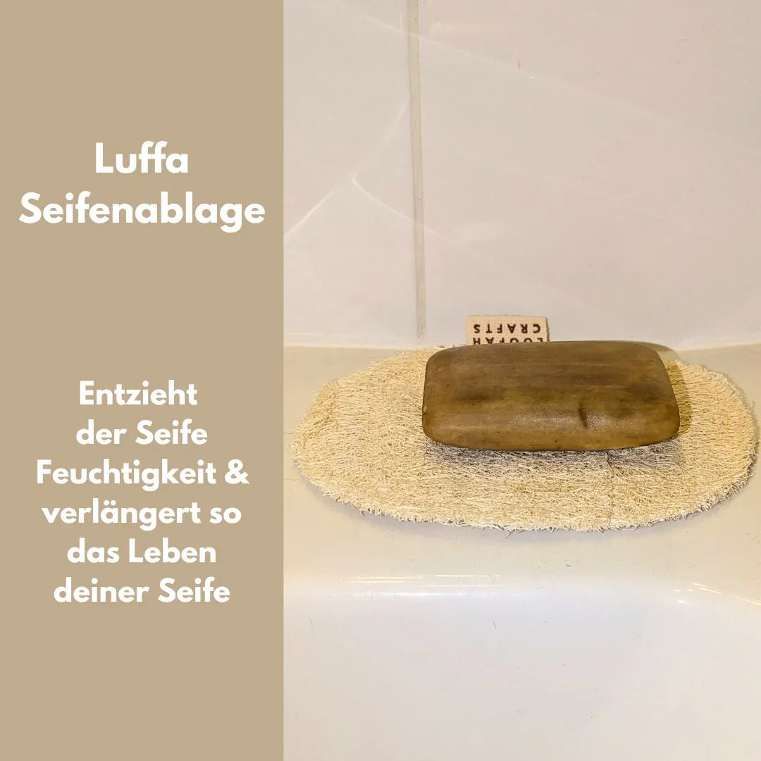 Ein Set aus vier hellen Luffa-Pflegeprodukten inklusive Handschuh und runden Pads auf einem Holzuntergrund.