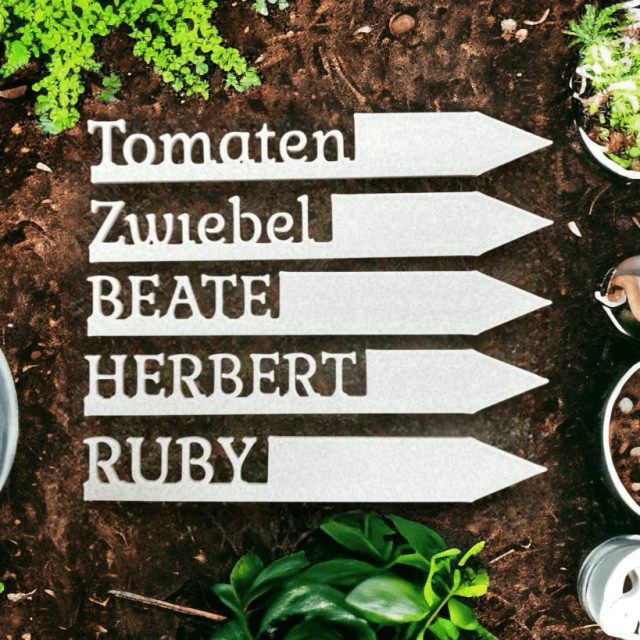 Weiße 3D-gedruckte Pflanzenschilder in Pfeilform mit Namen wie Tomaten und Zwiebel