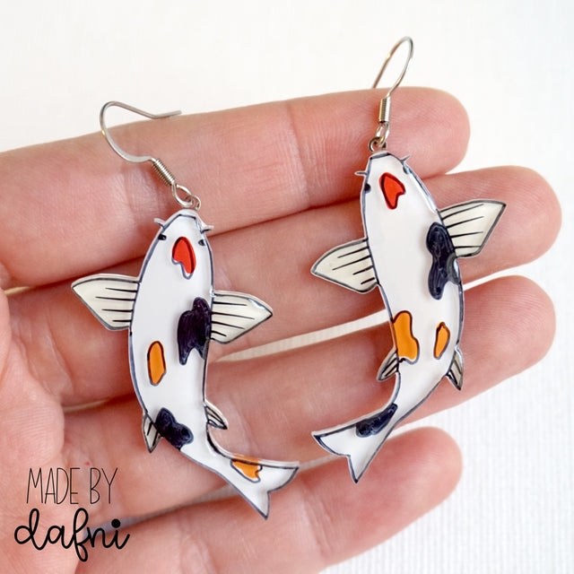 Handbemalter Acrylglas-Schmuck von MadeByDafni mit 3D-Effekten in lebhaften Farben, darstellend Tiere und Pflanzen, einschließlich Halsketten, Ohrringe und Broschen bei Dreizack Wien