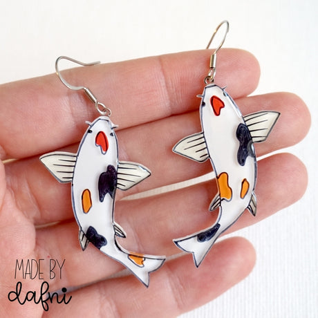 Handbemalter Acrylglas-Schmuck von MadeByDafni mit 3D-Effekten in lebhaften Farben, darstellend Tiere und Pflanzen, einschließlich Halsketten, Ohrringe und Broschen bei Dreizack Wien
