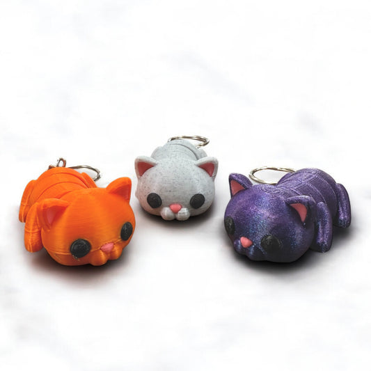 Schlüsselanhänger "Flexi-Katze" von Dreizack 3D-Druck: Bewegliche Katze aus nachhaltigem PLA in Farben wie Orange, Spacekitty (Blau-Violett-Verlauf) oder Marmor-Weiß, mit Edelstahl-Anhänger. Handgefertigt in Wien.