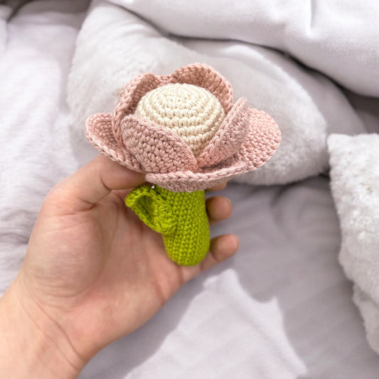 Handgehäkelte Baby-Rassel „Blumenfreude“ von LändleHäkel, ca. 10 cm groß. In zwei sanften Farben: Burgunderrot und Rosa Pastell. Babysicher und liebevoll gefertigt.