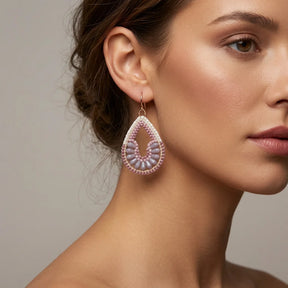 Handgeknüpfte Ohrringe aus rosa und lila Glasperlen mit rosegold gefärbten Haken.