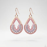 Handgeknüpfte Ohrringe aus rosa und lila Glasperlen mit rosegold gefärbten Haken.