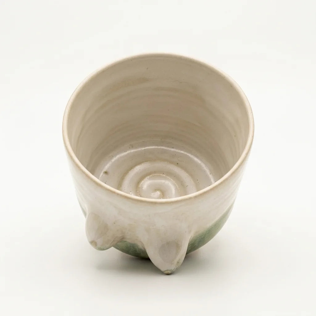 Handgetöpferter Keramikbecher mit weiblichen Brustformen und matter Glasur in natürlichen Farbtönen.