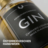 Eine 700ml Glasflasche Ashburner Cannabis Likör mit grünlichem Etikett vor hellem Hintergrund.