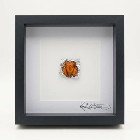 Miniatur eines gebratenen Huhns auf Alufolie, handmodelliert aus Polymer Clay mit Acrylfarben und Epoxidharz-Glasur, in schwarzem Echtholzrahmen mit Passepartout.