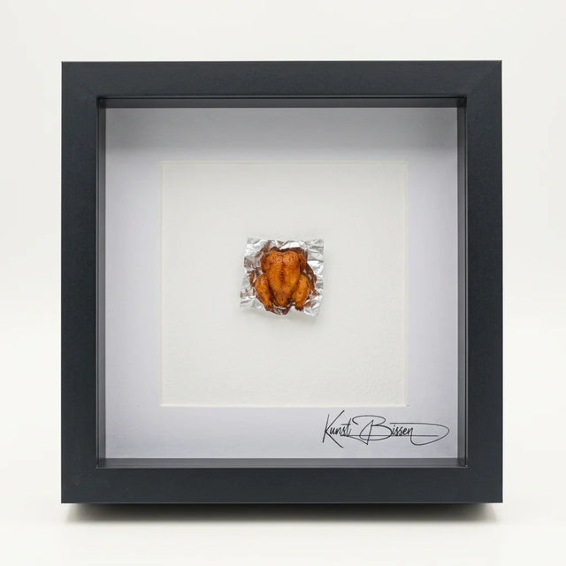 Miniatur eines gebratenen Huhns auf Alufolie, handmodelliert aus Polymer Clay mit Acrylfarben und Epoxidharz-Glasur, in schwarzem Echtholzrahmen mit Passepartout.
