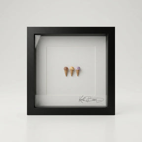 Drei handmodellierte Miniatur-Eiskugeln im schwarzen Echtholzrahmen mit Passepartout und Echtglas, 22×22 cm.