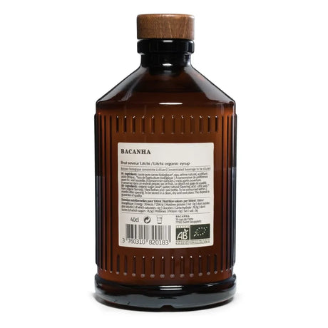 Braunglasflasche mit hellem Bio-Litschisirup und einem dunklen Holzstopfen. Auf dem Etikett steht „Bacanha Sirop de Litchi Bio“.