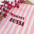 Grußkarte aus beigem Saatpapier mit Aufschrift „Dickes Bussi" und beiliegendem Kuvert.