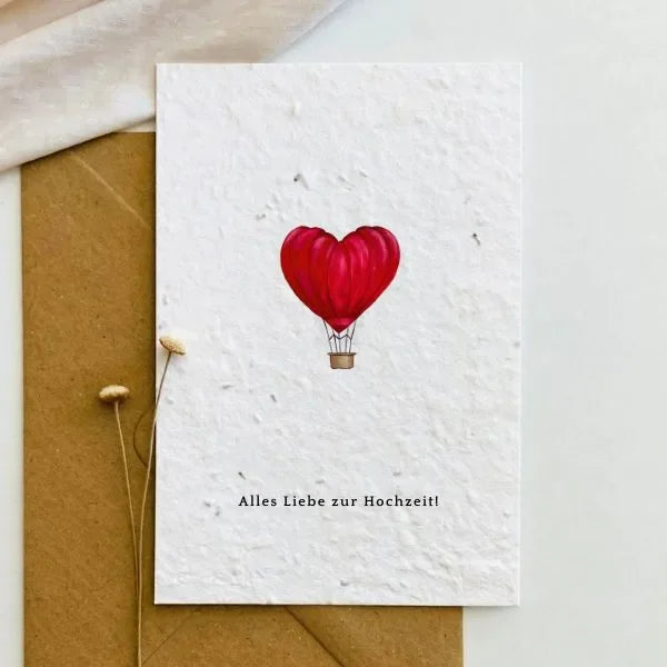 Hochzeitskarte aus beigefarbenem Saatpapier mit gemaltem rotem Heißluftballon in Herzform und Schriftzug Alles Liebe zur Hochzeit