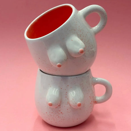 Weiße Keramiktasse mit rosa Sprenkelung und handgeformten Brüsten aus Keramik, Fassungsvermögen ca. 250 ml.