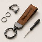 Brauner Leder Schlüsselanhänger mit D-Ring, zwei Zusatzringen aus Edelstahl und Federclip auf hellem Hintergrund.
