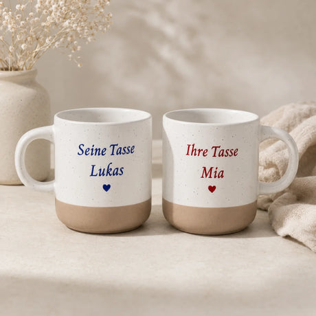 Weiß gesprenkelte Steingut Tasse mit farbig graviertem Wunschdesign und unglasiertem Boden.