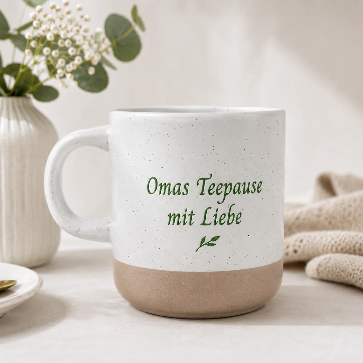 Weiß gesprenkelte Steingut Tasse mit farbig graviertem Wunschdesign und unglasiertem Boden.