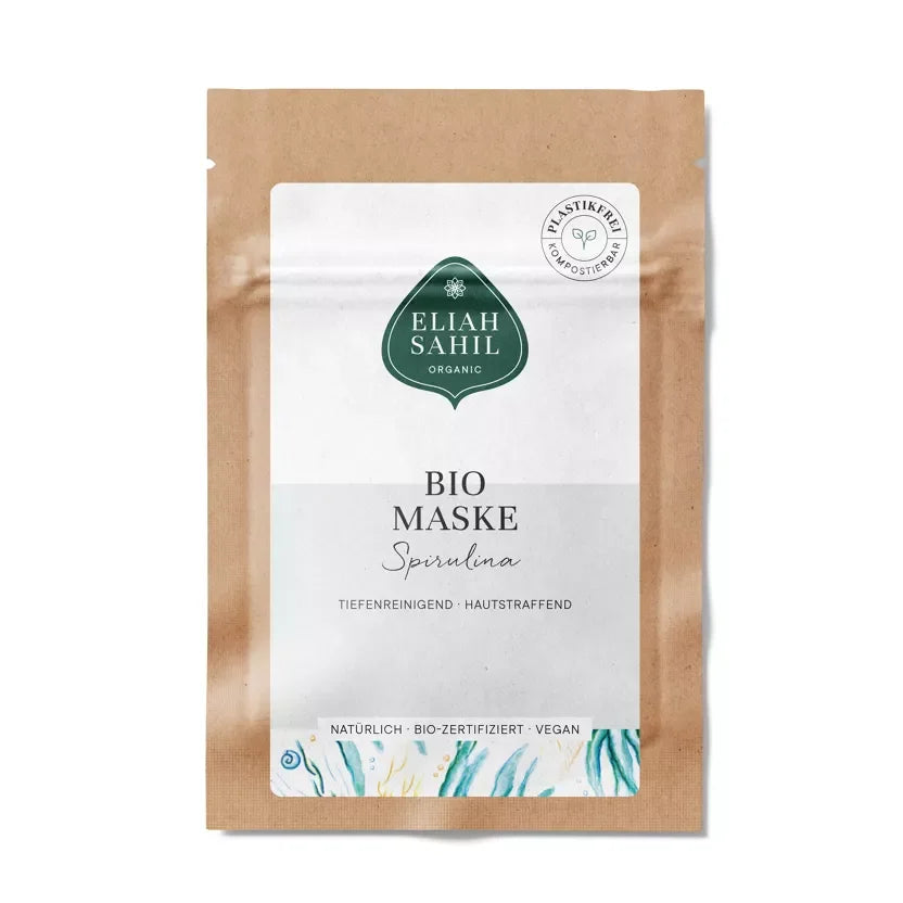 Nahaufnahme einer Bio Gesichtsmaske Spirulina in einer minimalistischen Glasverpackung, daneben eine angerührte grüne Paste. — 10g