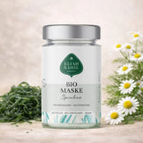 Nahaufnahme einer Bio Gesichtsmaske Spirulina in einer minimalistischen Glasverpackung, daneben eine angerührte grüne Paste.