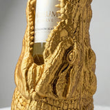 Ein dekorativer Flaschenhalter in Form eines Krokodilkopfes aus farbigem Kunststoff hält eine Weinflasche im Maul.