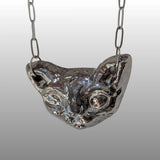 Silberne Halskette mit handgefertigtem, keramischem Anhänger in Form eines stilisierten Sphinxkatzenkopfes, glasiert mit 18k Titanglasur.