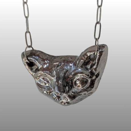 Silberne Halskette mit handgefertigtem, keramischem Anhänger in Form eines stilisierten Sphinxkatzenkopfes, glasiert mit 18k Titanglasur.