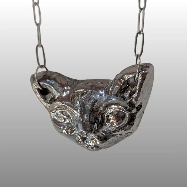 Silberne Halskette mit handgefertigtem, keramischem Anhänger in Form eines stilisierten Sphinxkatzenkopfes, glasiert mit 18k Titanglasur.