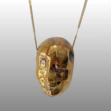 Halskette mit filigranem, anthropomorphen Keramik-Anhänger in Form eines Puppen-Kopfes, teilweise mit 18k Goldglasur veredelt.