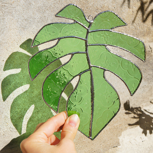 Monstera Blatt, Handgemachte Glasdeko von Magpie Castle, Tiffany-Technik, Naturmotive wie Monstera, Pilze & Blumen, zum Aufhängen oder als Pflanzenstecker, kunstvolle Glaskunst aus Österreich.