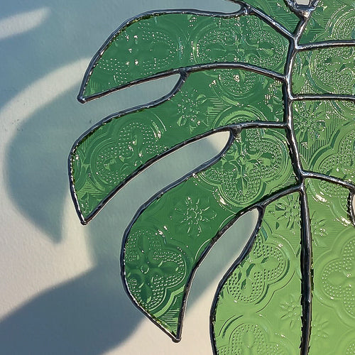 Monstera Blatt, Handgemachte Glasdeko von Magpie Castle, Tiffany-Technik, Naturmotive wie Monstera, Pilze & Blumen, zum Aufhängen oder als Pflanzenstecker, kunstvolle Glaskunst aus Österreich.