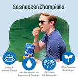 Drei Packungen Hempions Bio Hemp Flips mit Meersalz, vor einem hanfgrünen Hintergrund, verstreute Flips sichtbar.