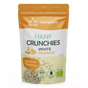 Hempions Bio Hanf Crunchies in Weiß und Orange gehalten. Detailansicht von gerösteten Hanfsamen umhüllt von weißer Kakaomasse und Orangenschalenöl in einem geöffneten Beutel. — 50g