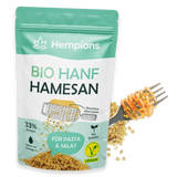 Bio Hanf Hamesan Streukäse Alternative in Pulverform, hellbraun mit kleinen Flocken, bereit zum Bestreuen.