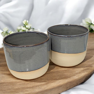 Handgemachte Keramiktasse M von ArtStudioIzzi, grau glasierte Oberfläche mit beigem Ton, 250 ml Fassungsvermögen, doppelt gebrannt, mikrowellen- und spülmaschinengeeignet.