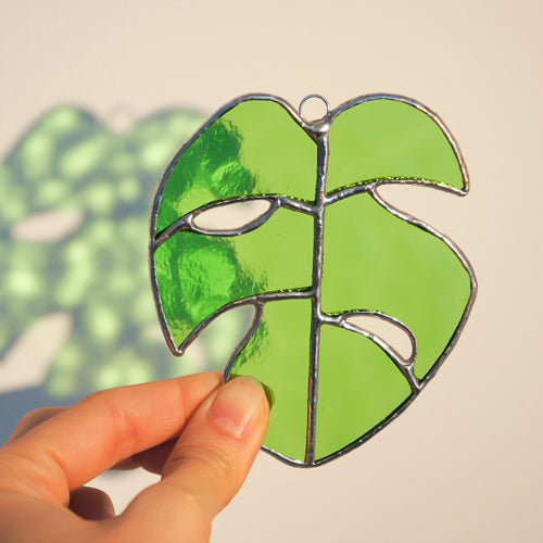 Monstera Blatt, Handgemachte Glasdeko von Magpie Castle, Tiffany-Technik, Naturmotive wie Monstera, Pilze & Blumen, zum Aufhängen oder als Pflanzenstecker, kunstvolle Glaskunst aus Österreich.