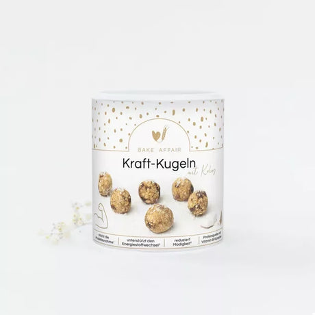 Weiße Schale mit Kraft-Kugeln mit Kokos und Vitamin B-Komplex auf hellem Hintergrund, bereit zum Verzehr.