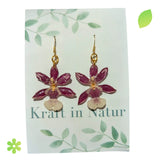 Paar Ohrringe mit echten, violett-weißen Orchideenblüten in transparentem Resin und glänzenden Ohrhaken.