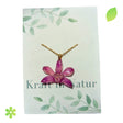 Halskette mit einer echten violetten Orchideenblüte, eingebettet in transparentes Harz, an einer goldfarbenen Kette.