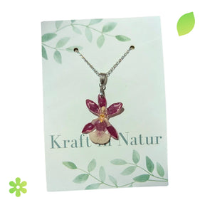 Violette Orchideenblüte in transparentem Resin, an einer feinen silbernen Halskette.