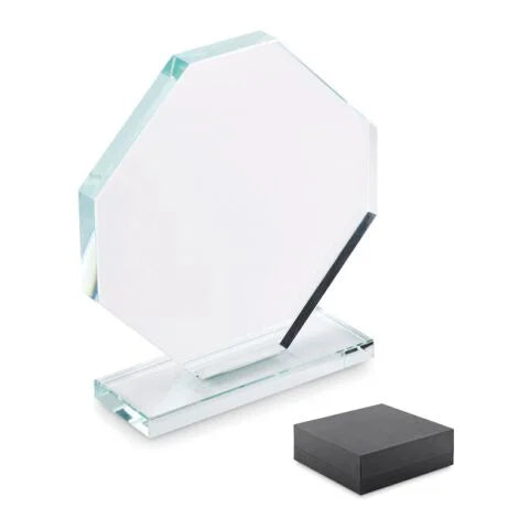 Ein achteckiger Pokal aus klarem Kristallglas auf einem flachen Sockel mit weißer Gravur