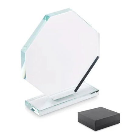 Ein achteckiger Pokal aus klarem Kristallglas auf einem flachen Sockel mit weißer Gravur