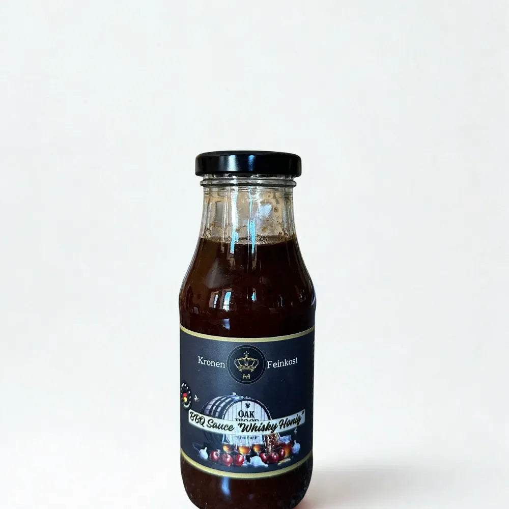 Eine Glasflasche mit dunkler, sämiger BBQ Sauce „Smoky Bourbon Honey“ von Kronenfeinkost.
