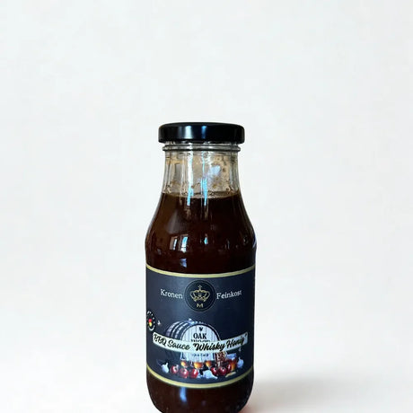 Eine Glasflasche mit dunkler, sämiger BBQ Sauce „Smoky Bourbon Honey“ von Kronenfeinkost.