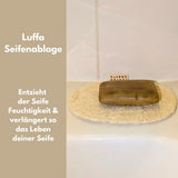 Ein Set aus vier hellen Luffa-Pflegeprodukten inklusive Handschuh und runden Pads auf einem Holzuntergrund.