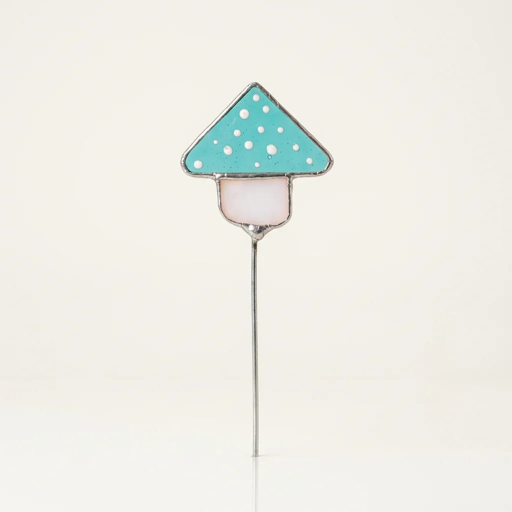 Pflanzenstecker aus hellblauem Glas in Fliegenpilz-Form, gefertigt in Tiffany-Technik mit sichtbaren Kupferfolien-Nähten.